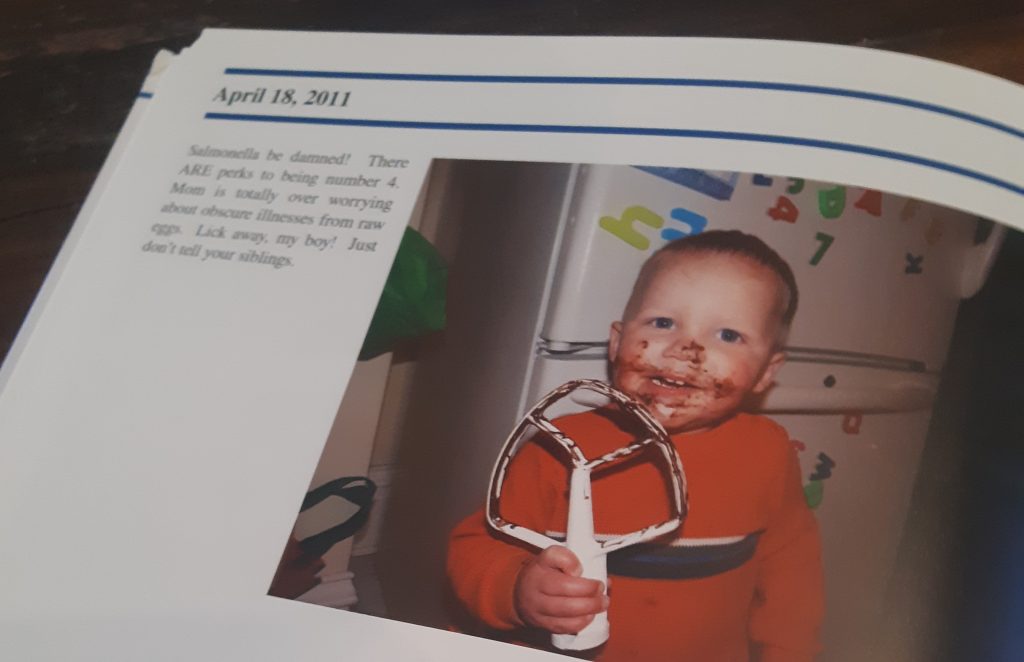 What can happen in twenty years? Picture of a Recap Book with image of toddler eating chocolate off a mixer attachment. Caption and date are included to identify the memory.